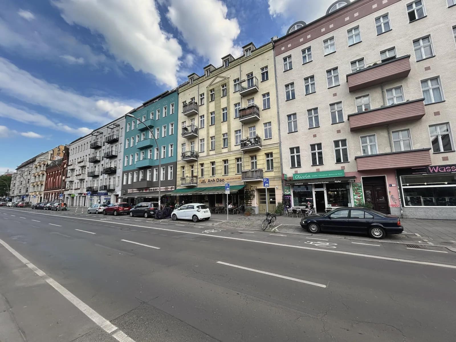 Straßenzug mit Gründerzeithäusern in Prenzlauer Berg, im Erdgeschoss Ladenlokale und Gastronomie